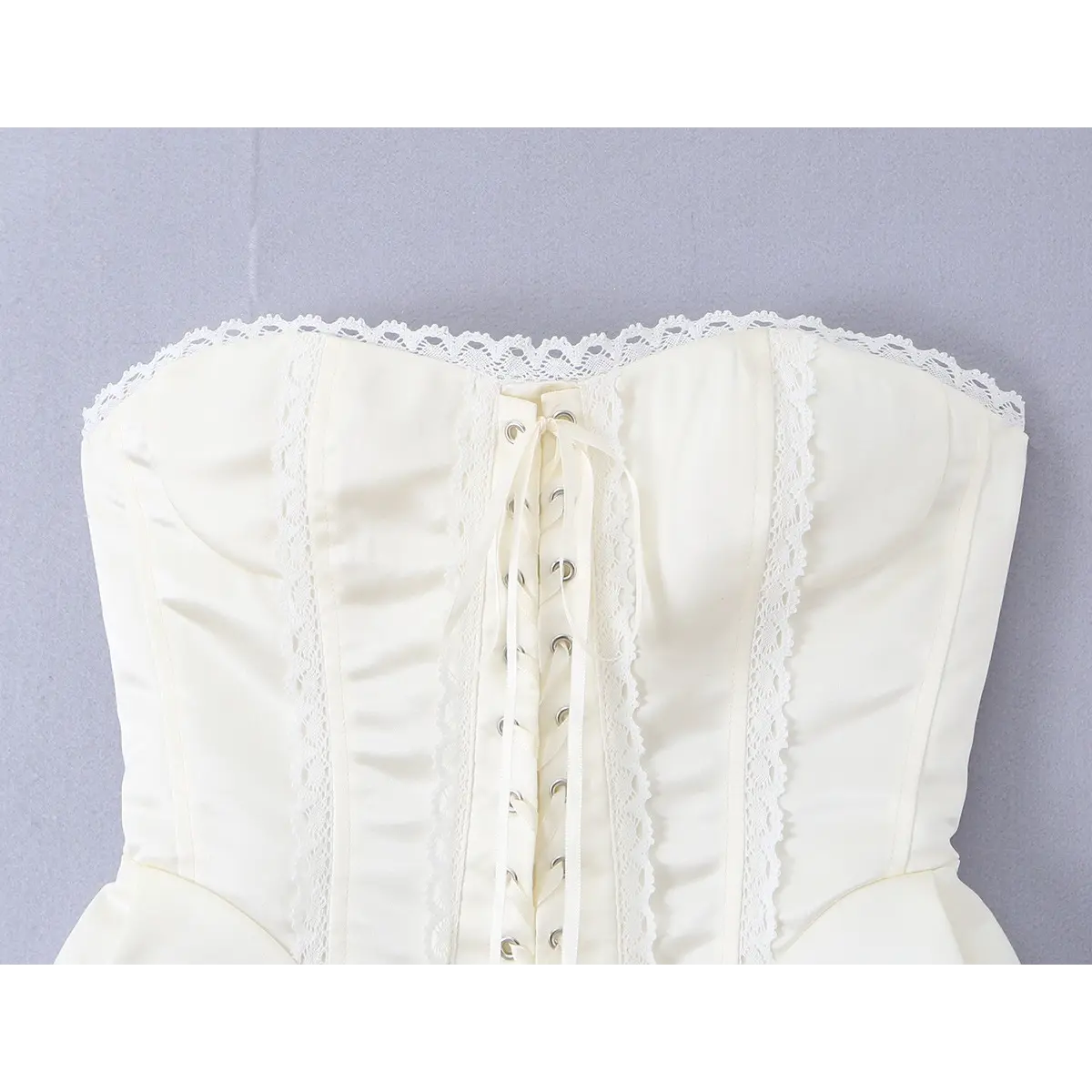 Close-up view of the cream lace-trimmed corset bustier, focusing on its tailored silhouette