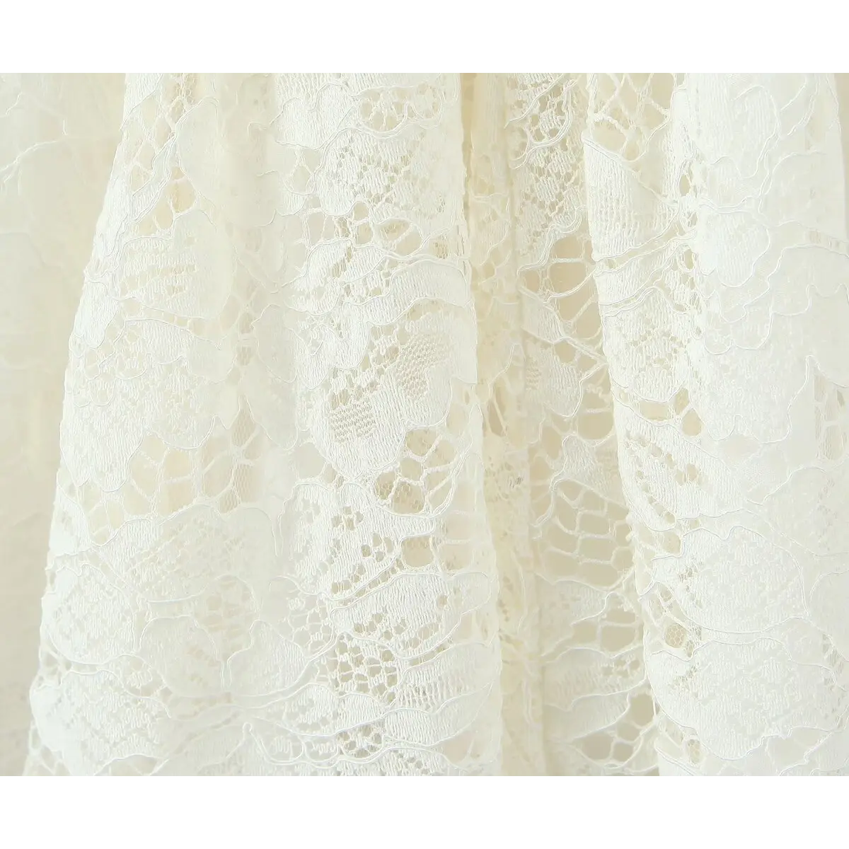 Close-up of the intricate floral lace pattern on the bodice of a cream-colored dress.