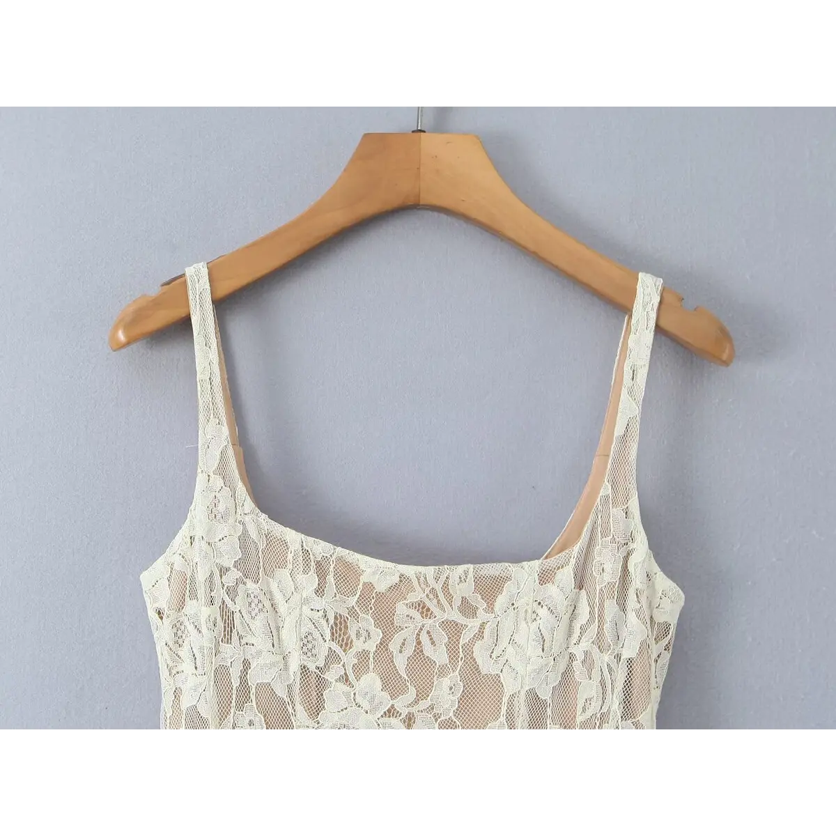 Close-up of the delicate lace spaghetti straps and the square-cut neckline.