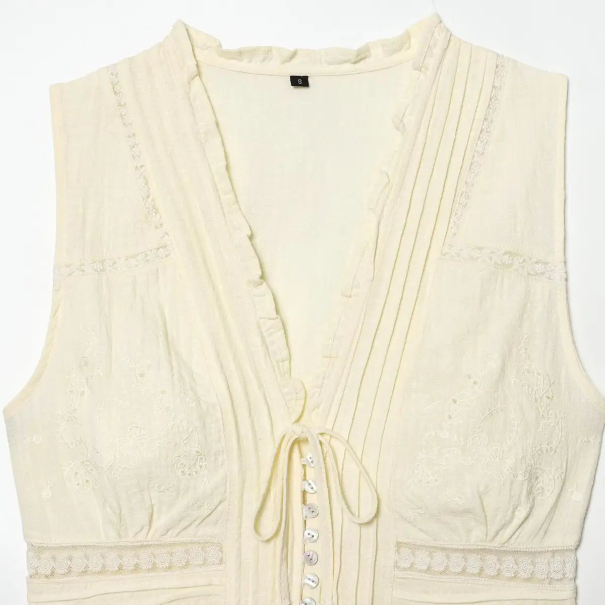 Close-up of the front tie and shell buttons on the cream bustier top, highlighting the mother-of-pearl finish
