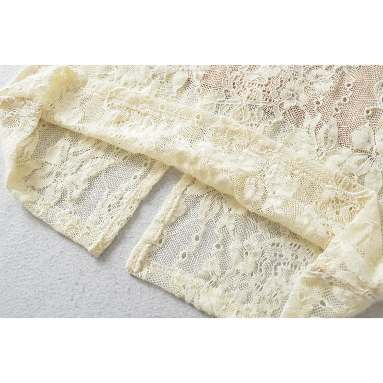 Close‑up of back hem vertical slit, double‑layer floral lace fabric, finished lace edge workmanship