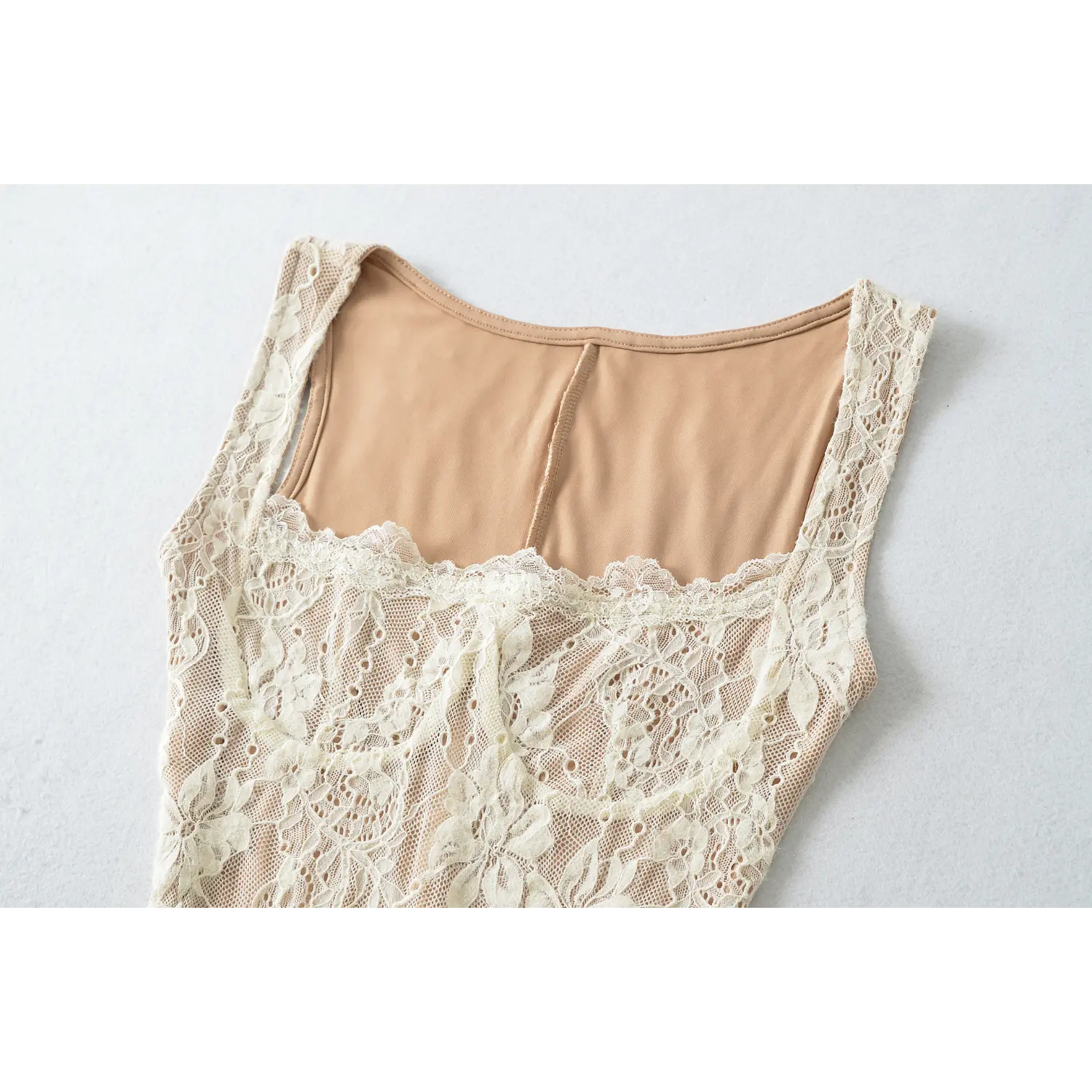 Close‑up shot of cream lace dress front neckline, scalloped floral lace trim and nude inner lining stitching detail