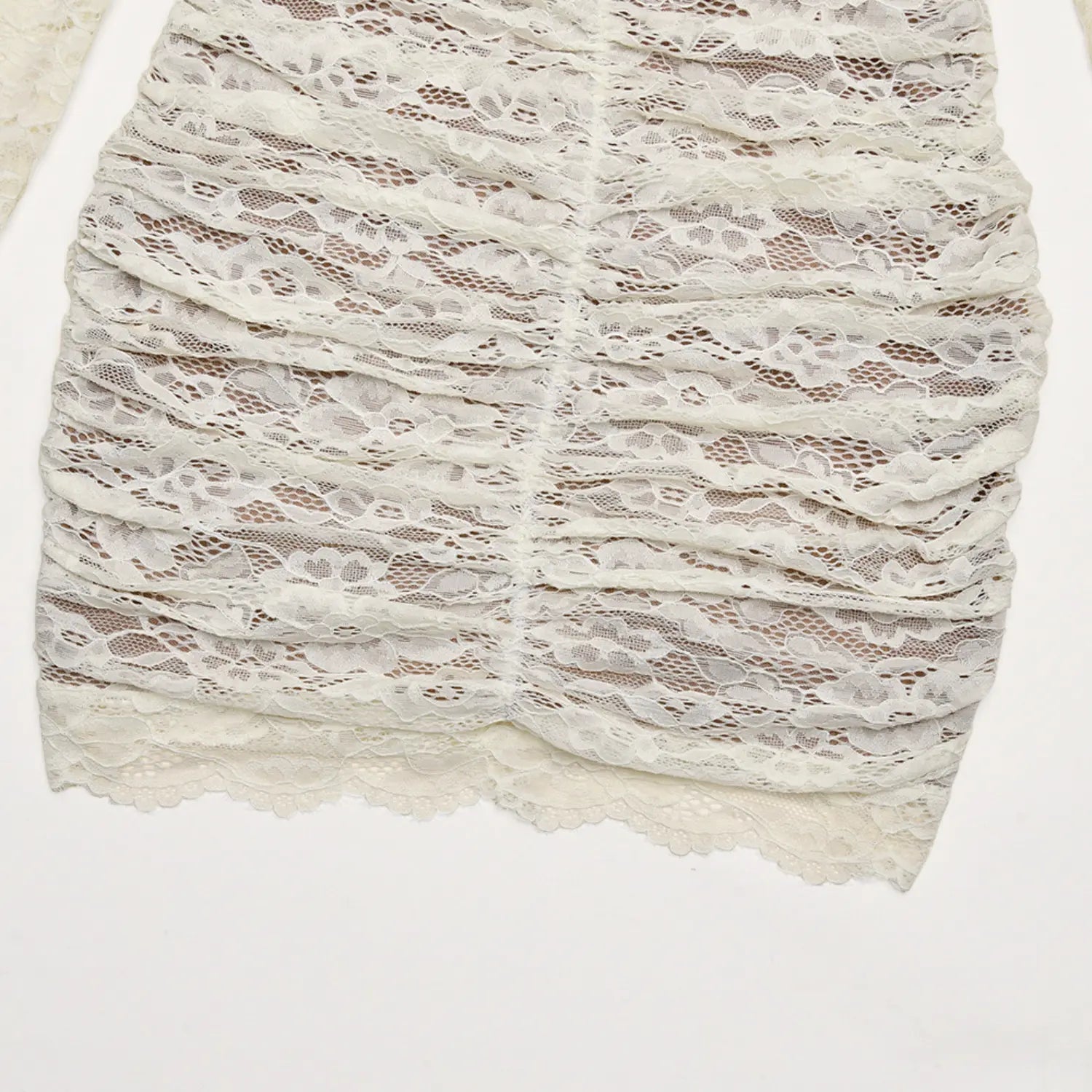 Flat lay cream lace ruched skirt hem scalloped edge fabric closeup