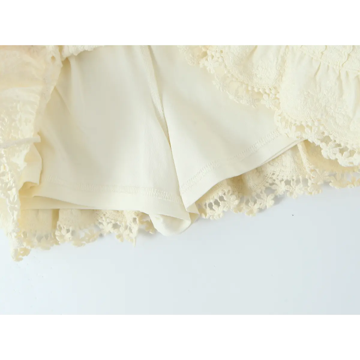 Close-up of the inner lining and ruffled hem on the cream crochet skirt