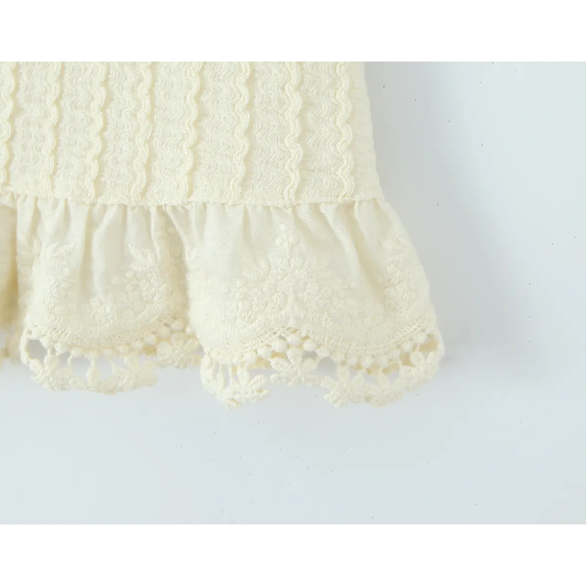 Close-up of the ruffled lace hem on the cream crochet mini skirt