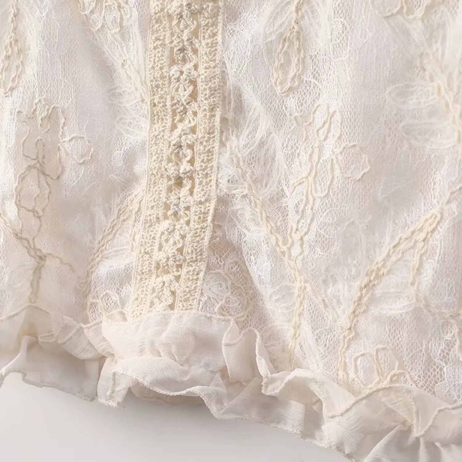 Close up front lace placket and floral embroidery texture of cream sleeveless lace top