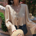 Close-up shot of a model wearing a cream lace-trim chiffon blouse, highlighting the V-neck and lace embroidery.