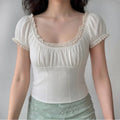 The top styled on a model, highlighting its vintage-inspired silhouette and lace details.