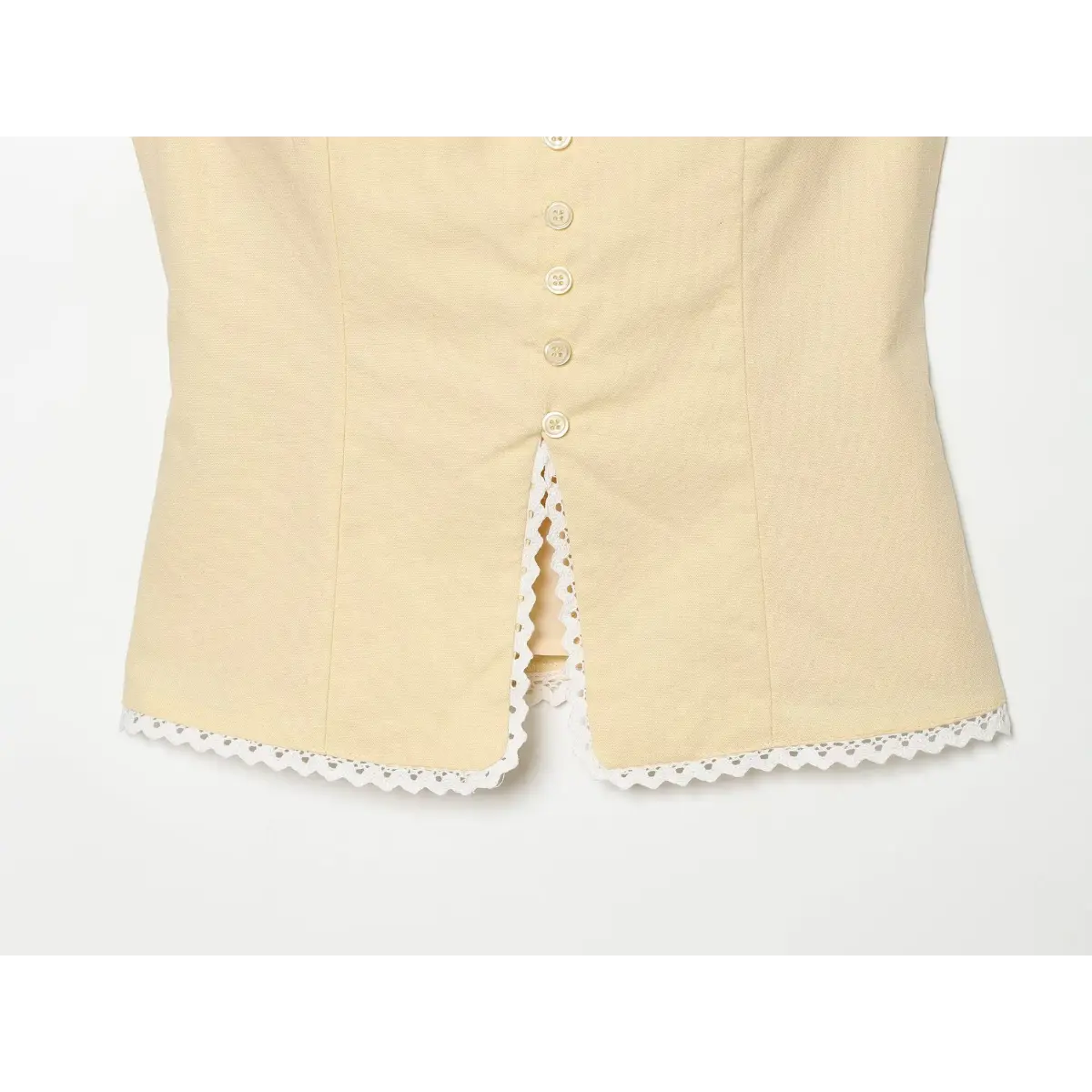 Bottom view of a cream-colored top showing the lace-trimmed hem and front button placket.