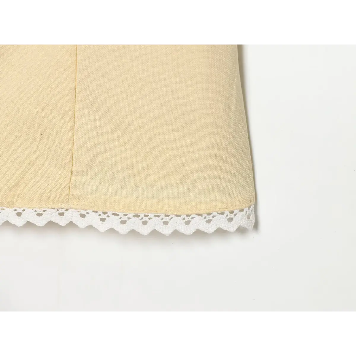Close-up of the lace-trimmed hem on a cream-colored top.