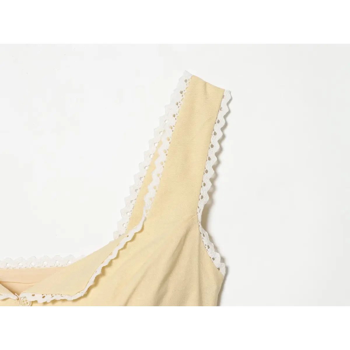 Close-up of the lace-trimmed shoulder strap on a cream-colored top.
