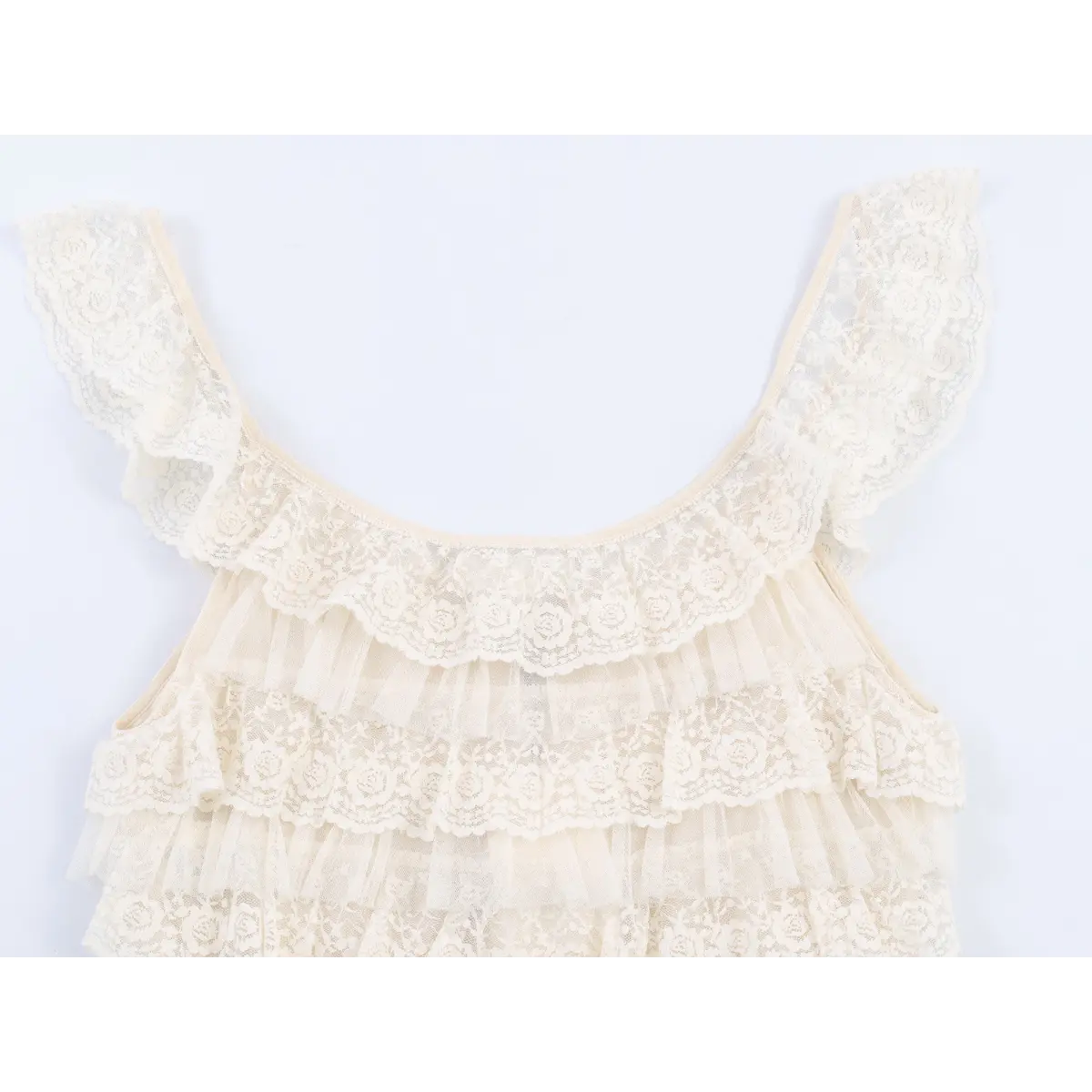 Close-up view of the U-neckline and lace-trimmed straps on a cream layered lace camisole, showing the floral lace pattern.
