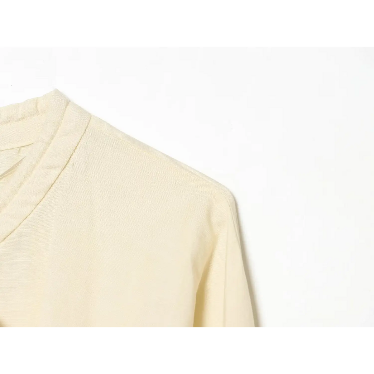Close‑up view of shoulder and lightweight textured cream linen blend fabric