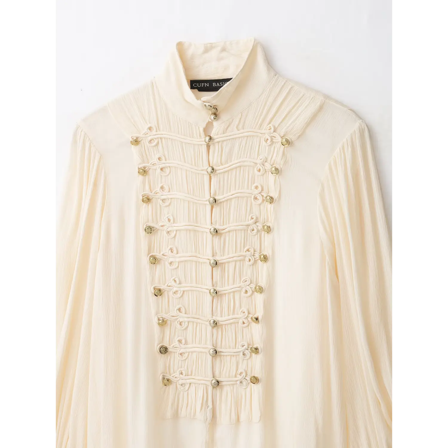 Close‑up front placket, mandarin stand collar, multi‑row frog knots and gold metal buttons