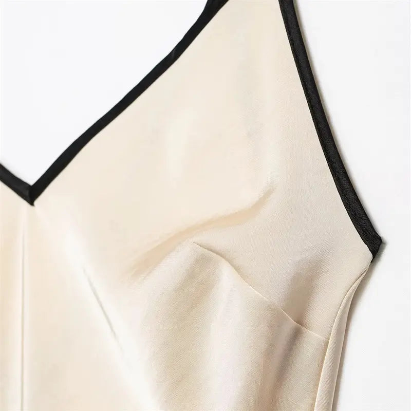 Shoulder double thin spaghetti strap closeup, metal adjustable slider, shoulder seam edged with black piping trim, smooth satin surface