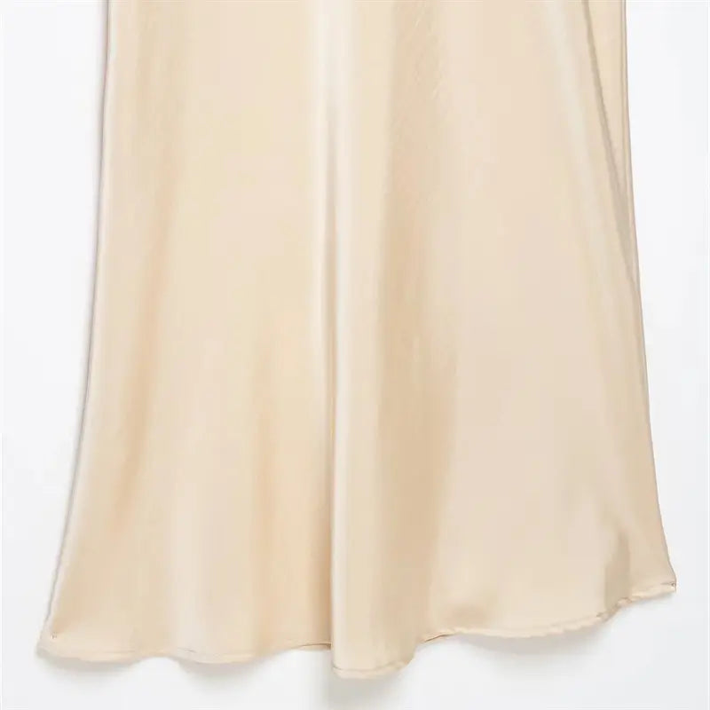 Long skirt bottom hem vertical side seam closeup, narrow folded clean finishing stitching, soft flowing satin fabric