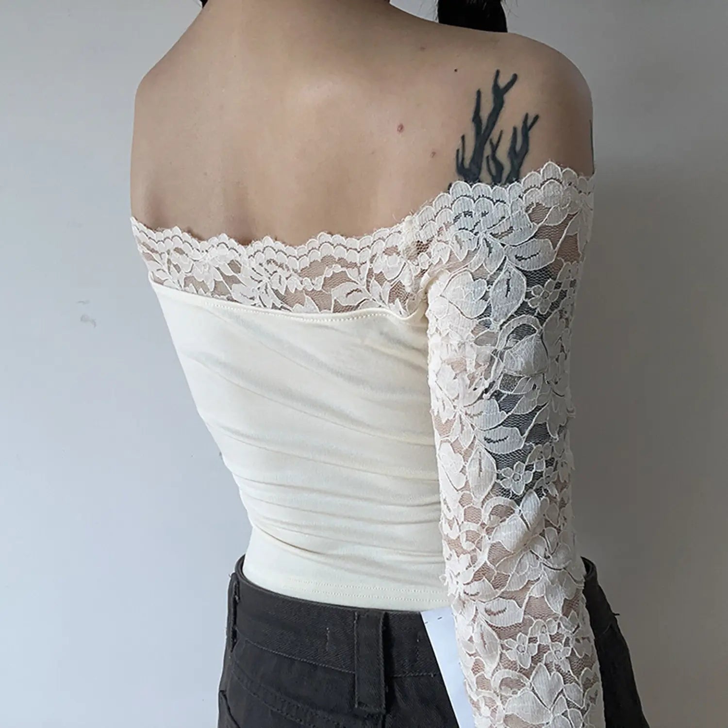 Model back view of cream off‑shoulder lace long sleeve cropped top