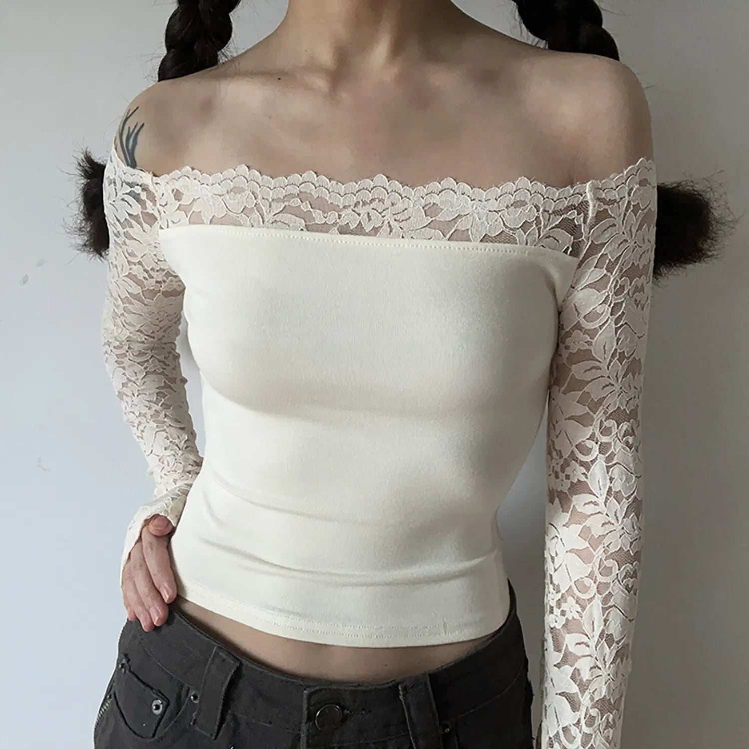 Model front view of cream off‑the‑shoulder cropped top with sheer floral lace long sleeves