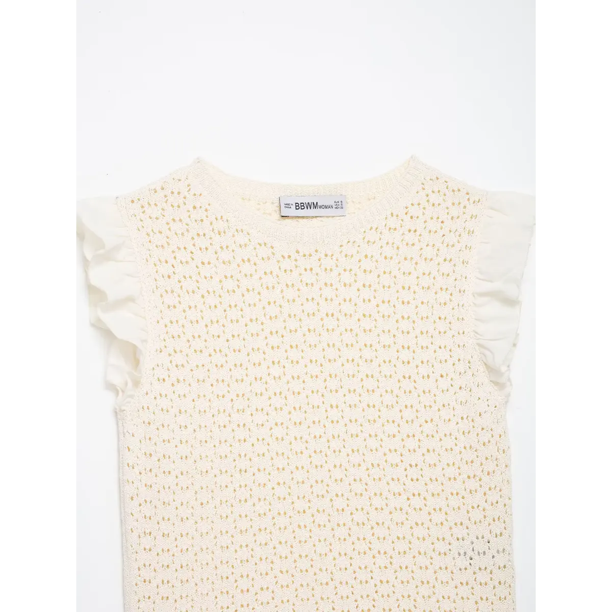 Front view of cream openwork knit top, showing the round neckline, ruffled sleeves, and brand label