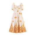 Full front view of cream maxi dress with orange paisley ethnic print, puff short sleeves and square neck