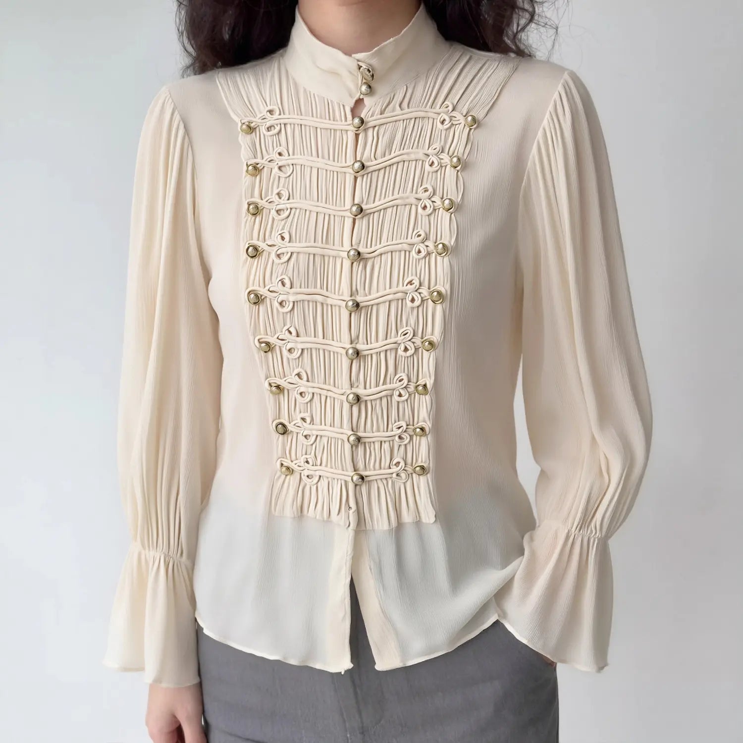 Women cream mandarin collar blouse with decorative frog buttons and bell sleeves, worn on model