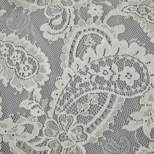 Macro close-up of cream paisley lace fabric