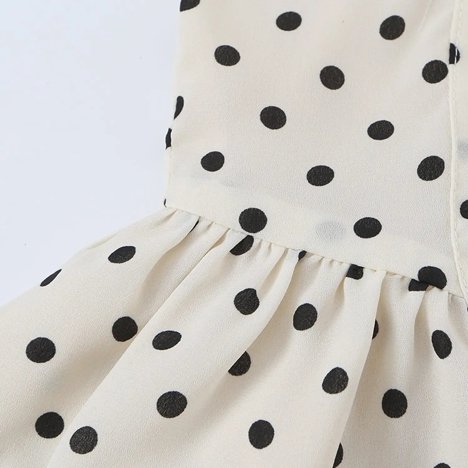 Cream black polka dot chiffon cami bust macro close-up, cross ruched v-neck drapey dot printed chiffon fabric texture