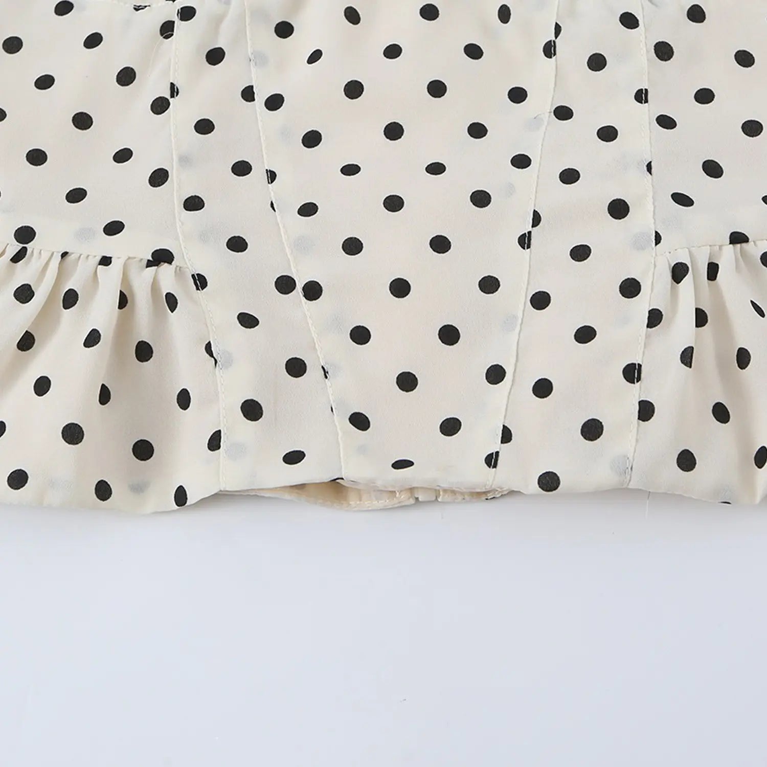 Cream black polka dot cami top full back flat lay, square back neck center invisible zipper matching lining peplum hem white background shot