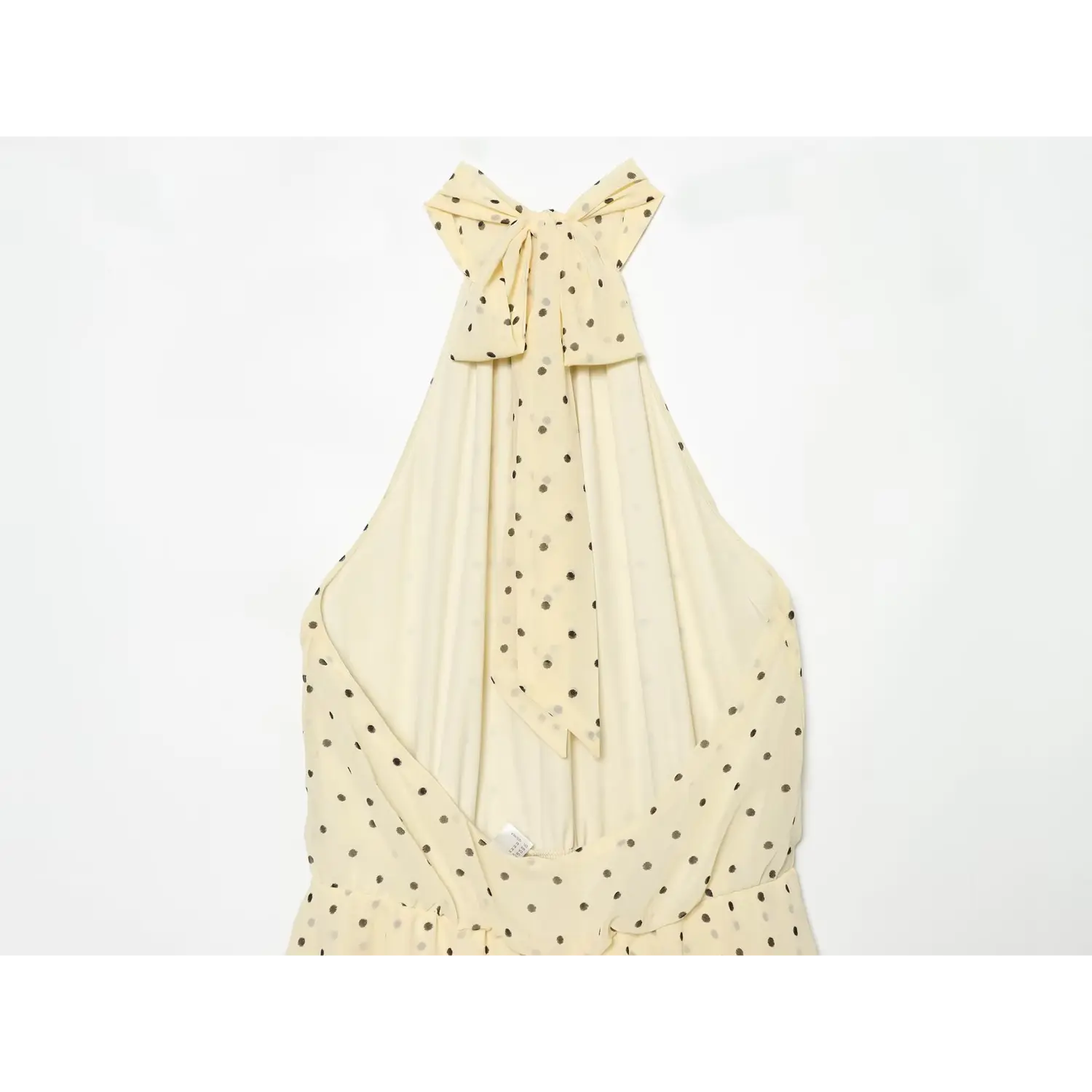 Back close-up of self-fabric halter neck tie bow, open low back design and smocked elastic waist panel