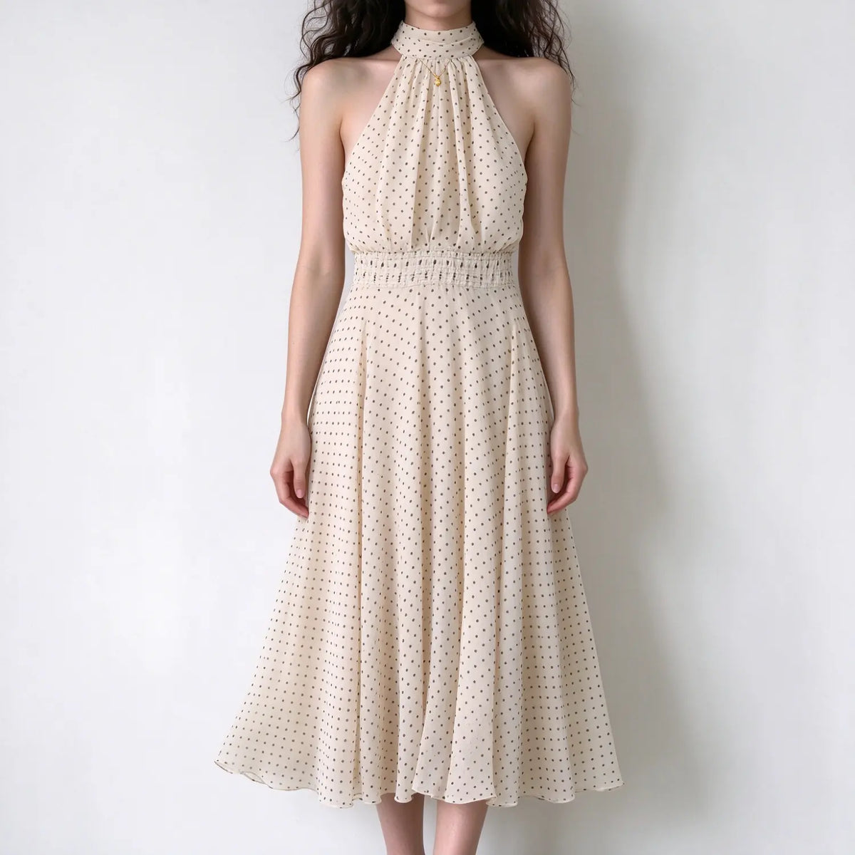 Model wearing cream brown polka dot halter maxi dress, smocked elastic waist, flared maxi skirt, chiffon material, white background
