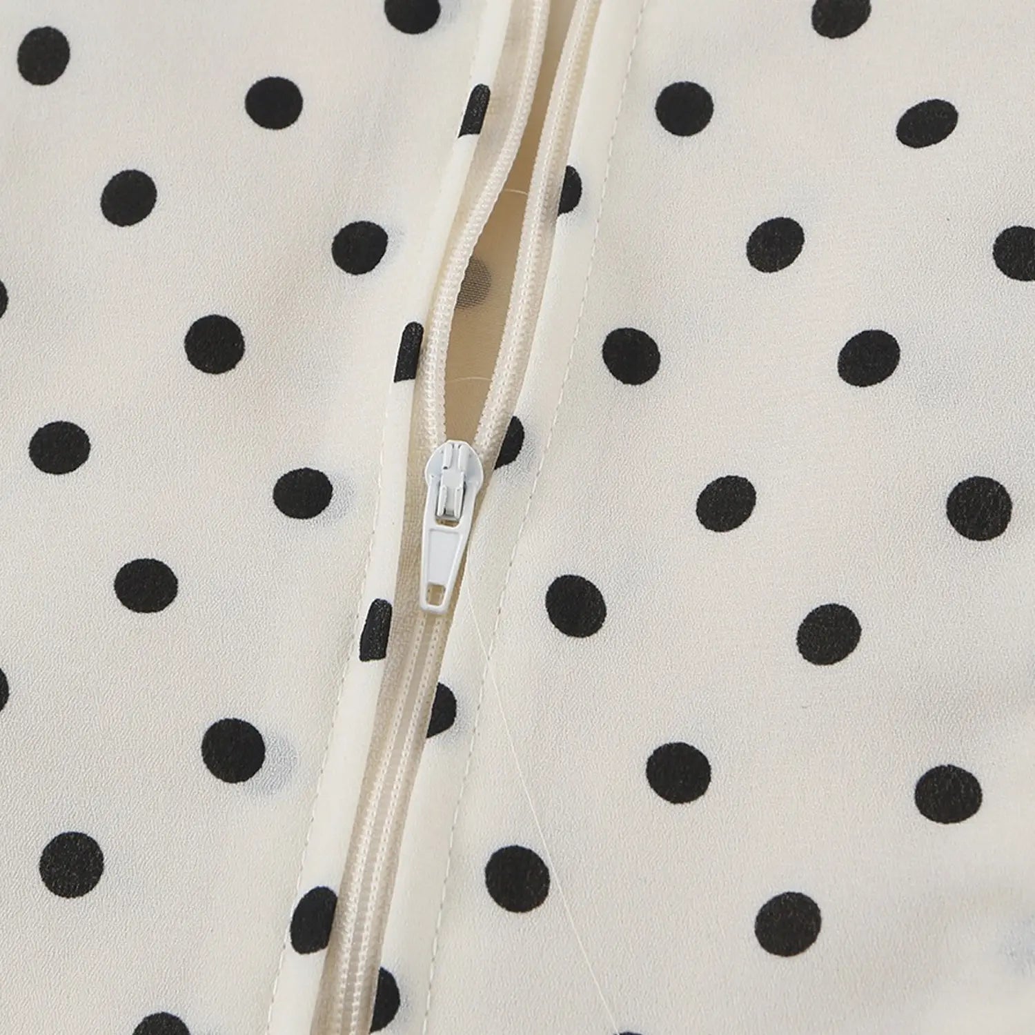 Cream black polka dot chiffon cami back invisible zipper macro shot, white hidden zipper and stitched chiffon fabric flat lay detail