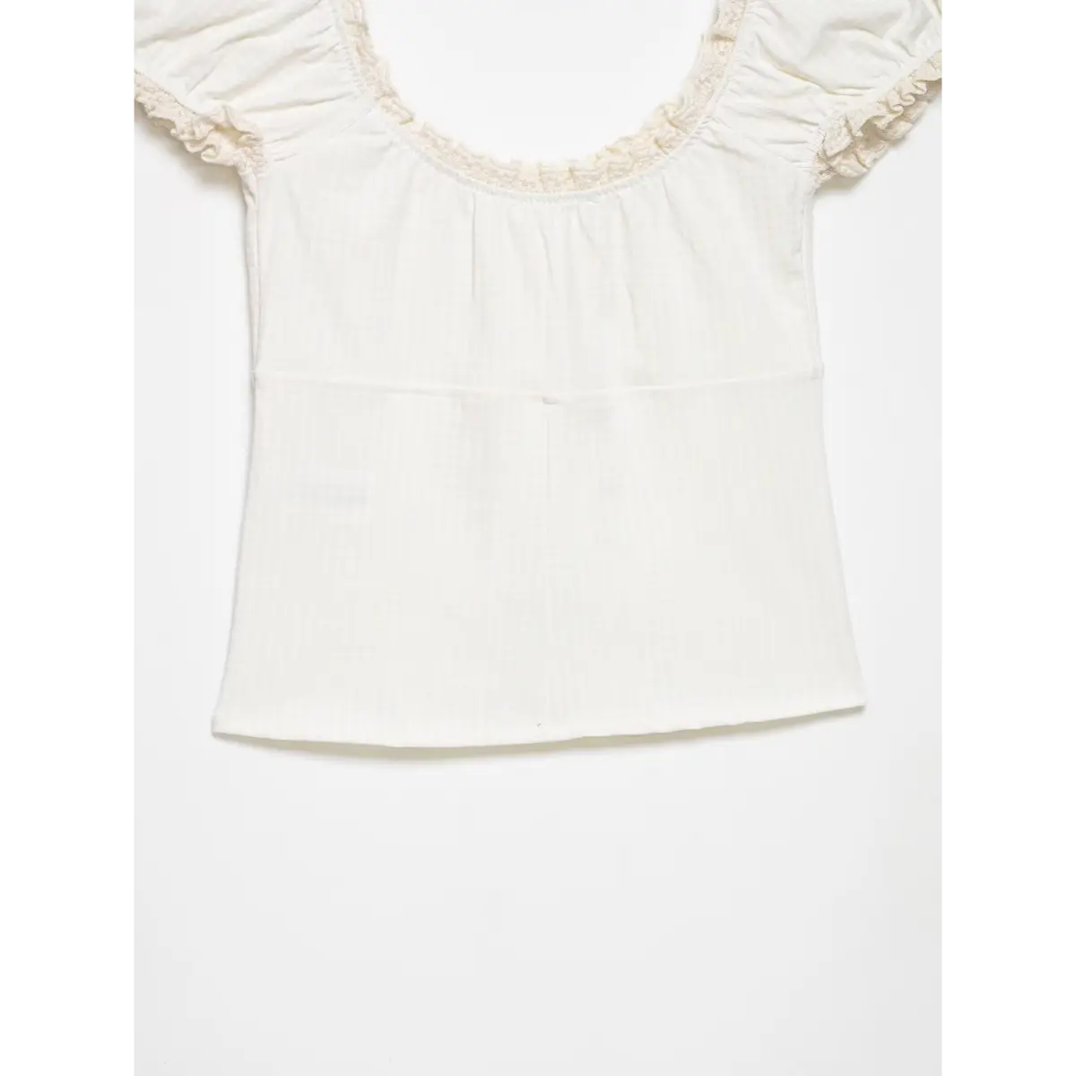 Back view of the cream puff-sleeve top, showing the gingham texture and fitted silhouette.