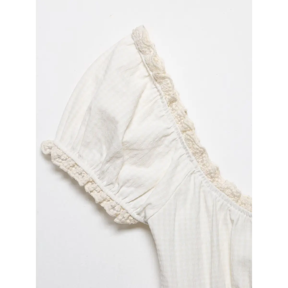 Close-up of the puff sleeve's lace-trimmed cuff, showing the gathered edge and fabric texture.
