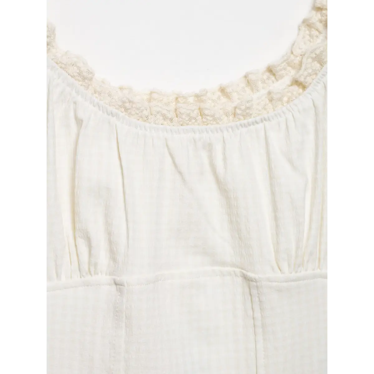 Close-up of the scoop neckline, highlighting the lace trim and gathered fabric at the bust.