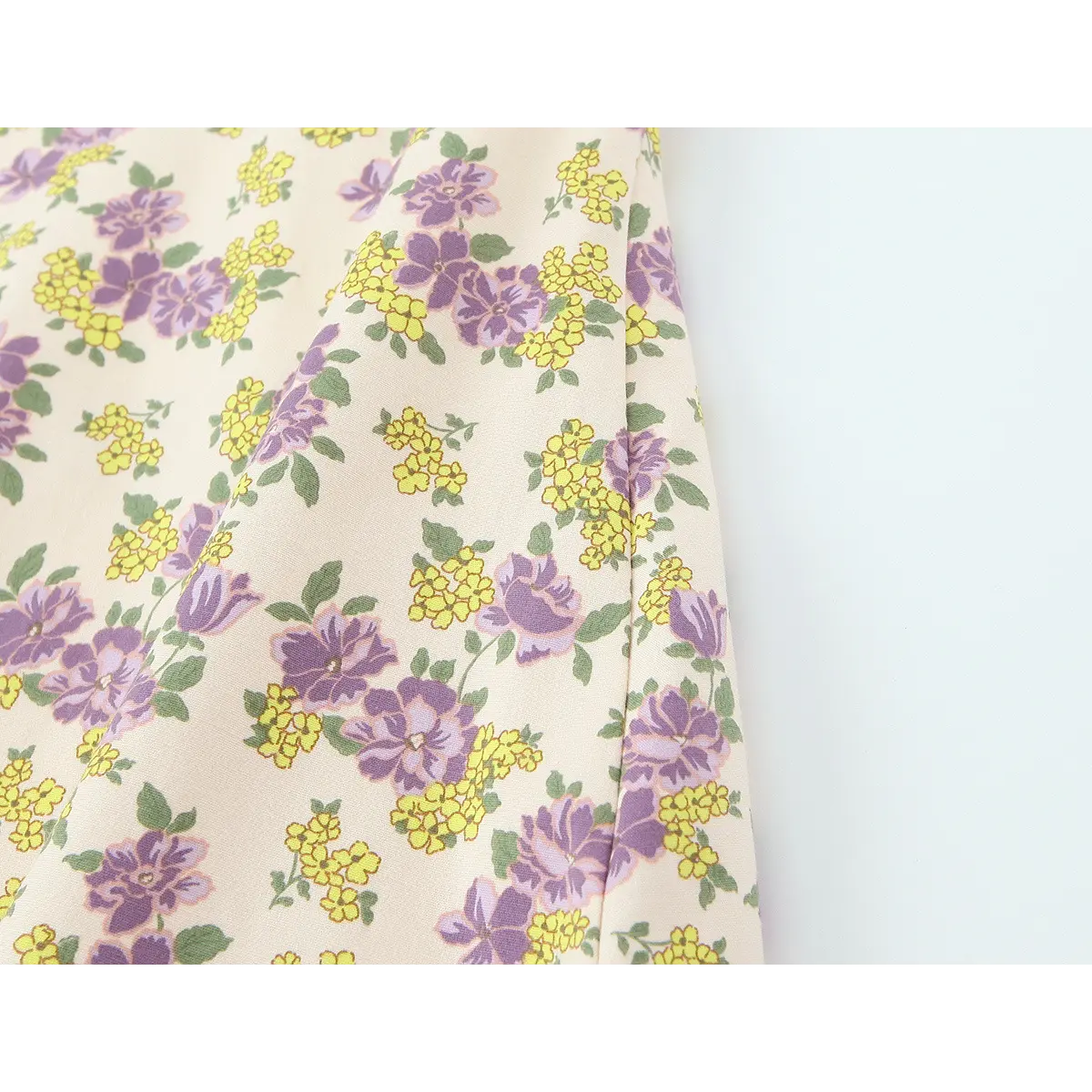 Fabric close-up of the cream floral dress, showing the soft texture and detailed floral print pattern
