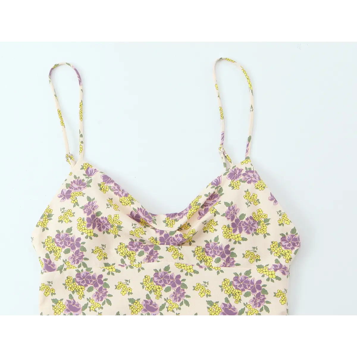 Front view of the cream floral dress, showing the spaghetti straps, cowl neckline, and floral print