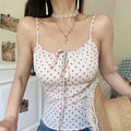 Lifestyle shot of model wearing cream red polka dot cami top with tie detail