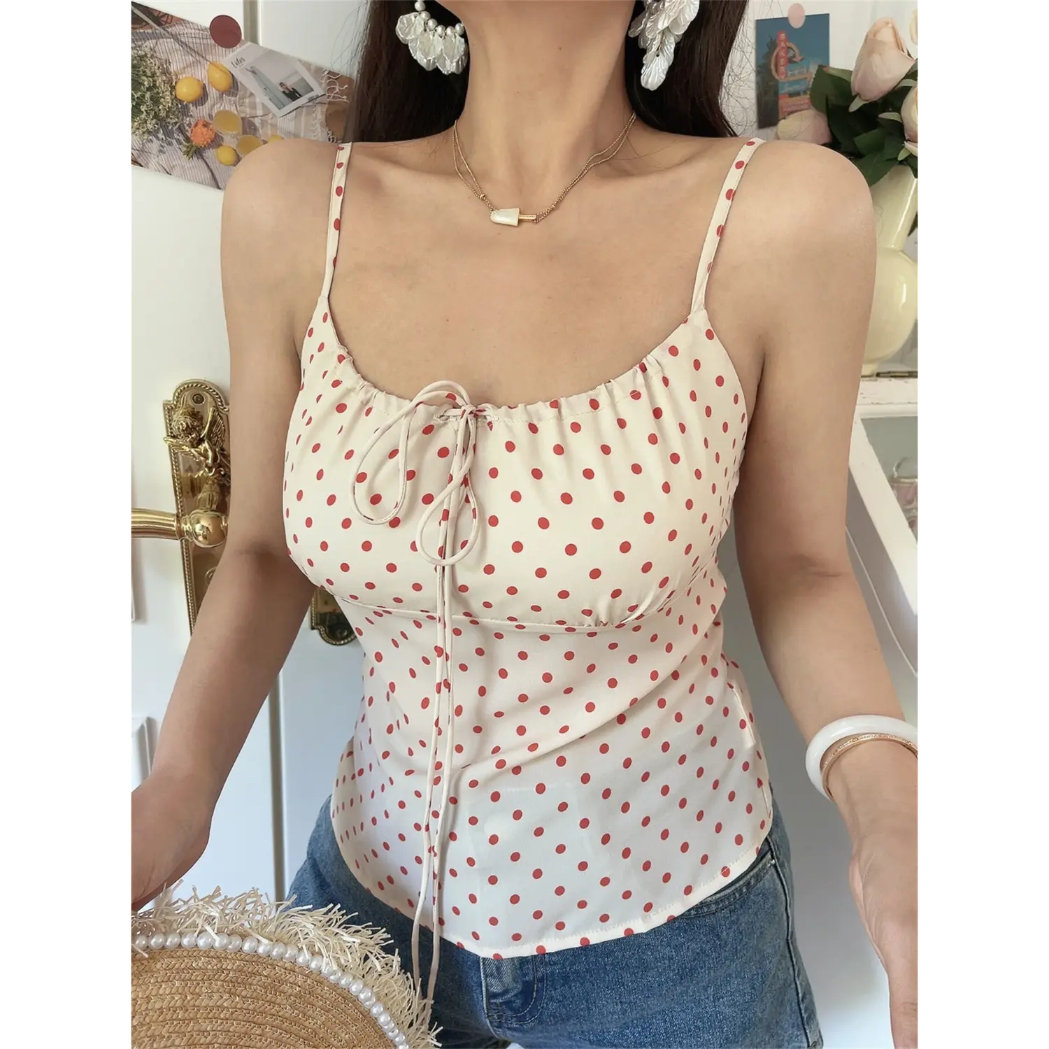 Front view lifestyle shot of cream red polka dot cami with jeans