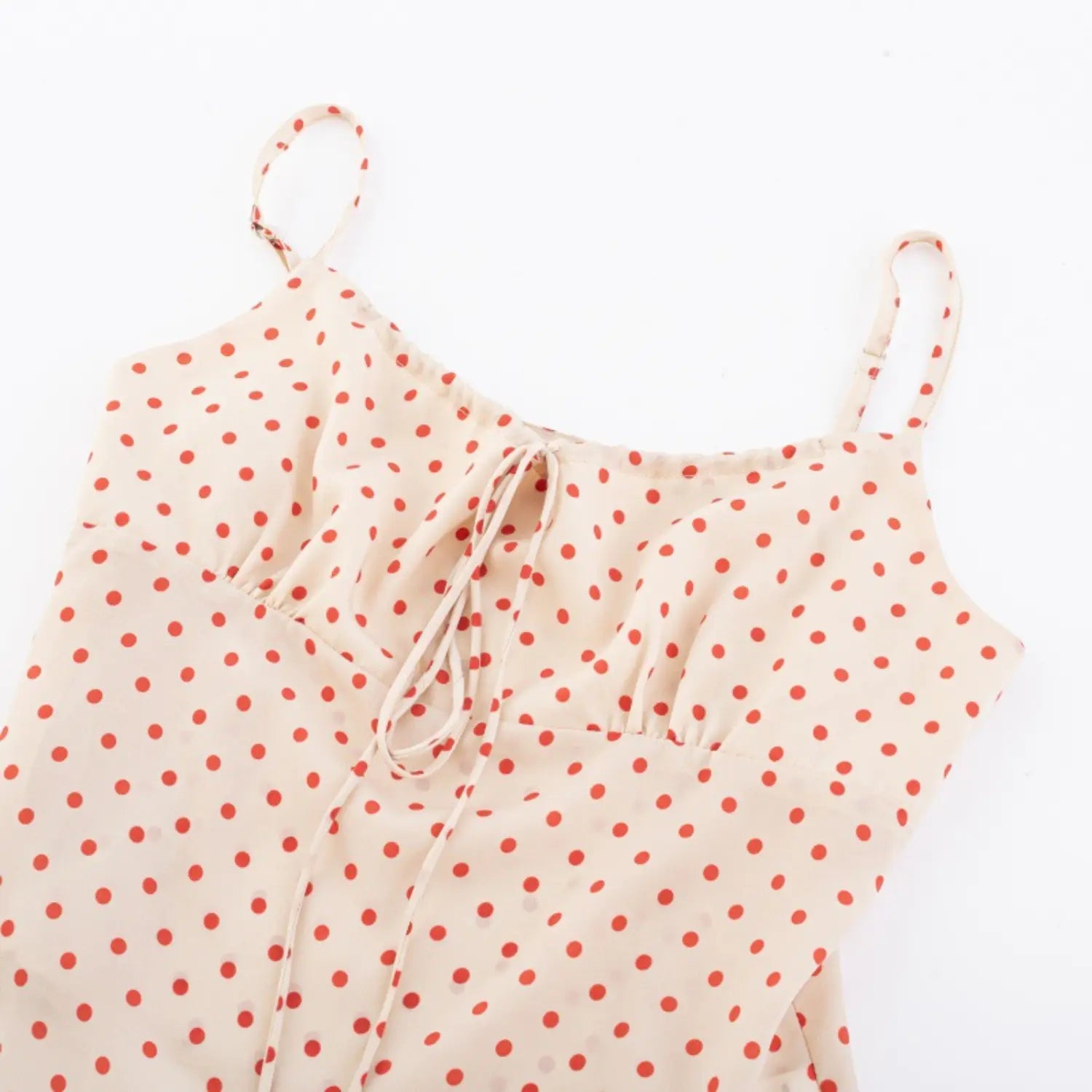 Full front view on white background of cream red polka dot camisole with drawstring detail
