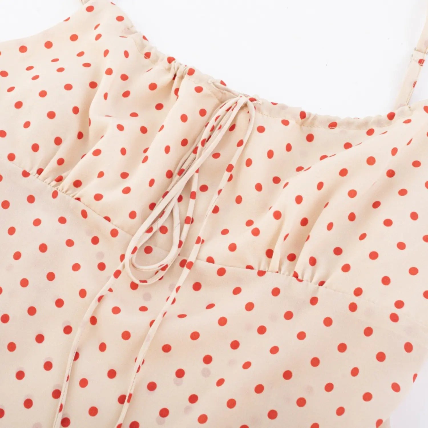 Close-up of the drawstring tie detail at the bust on cream red polka dot camisole