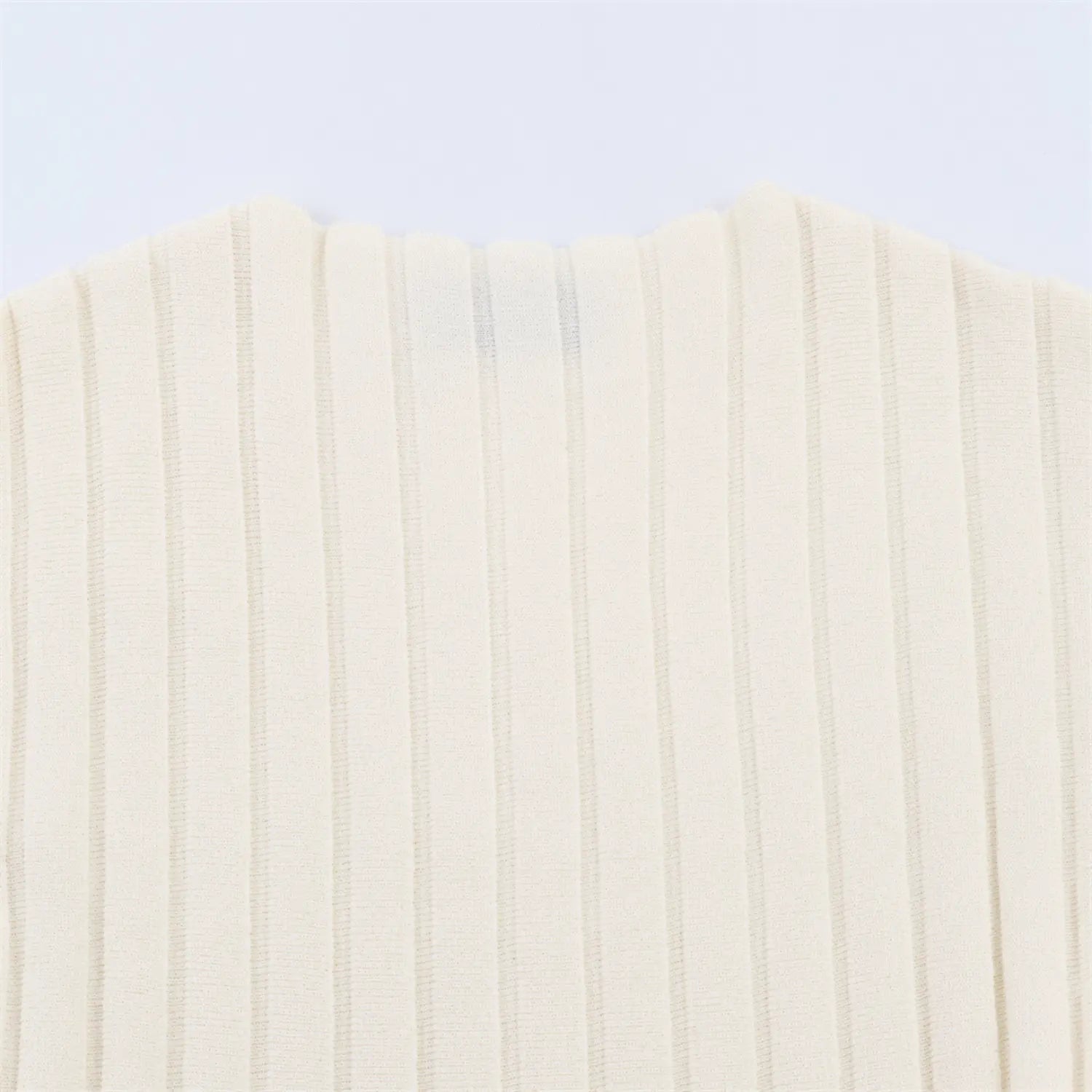 Fabric close-up detail of cream vertical ribbed knit material for mini dress