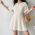 Model front view wearing cream ribbed knit mini dress, round neck short sleeve A-line silhouette