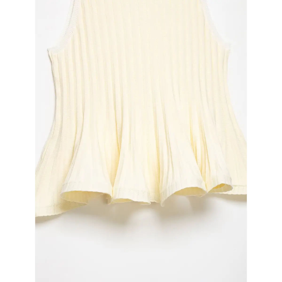 Back view of the cream ribbed knit top, showing the flared peplum hem and clean side seams