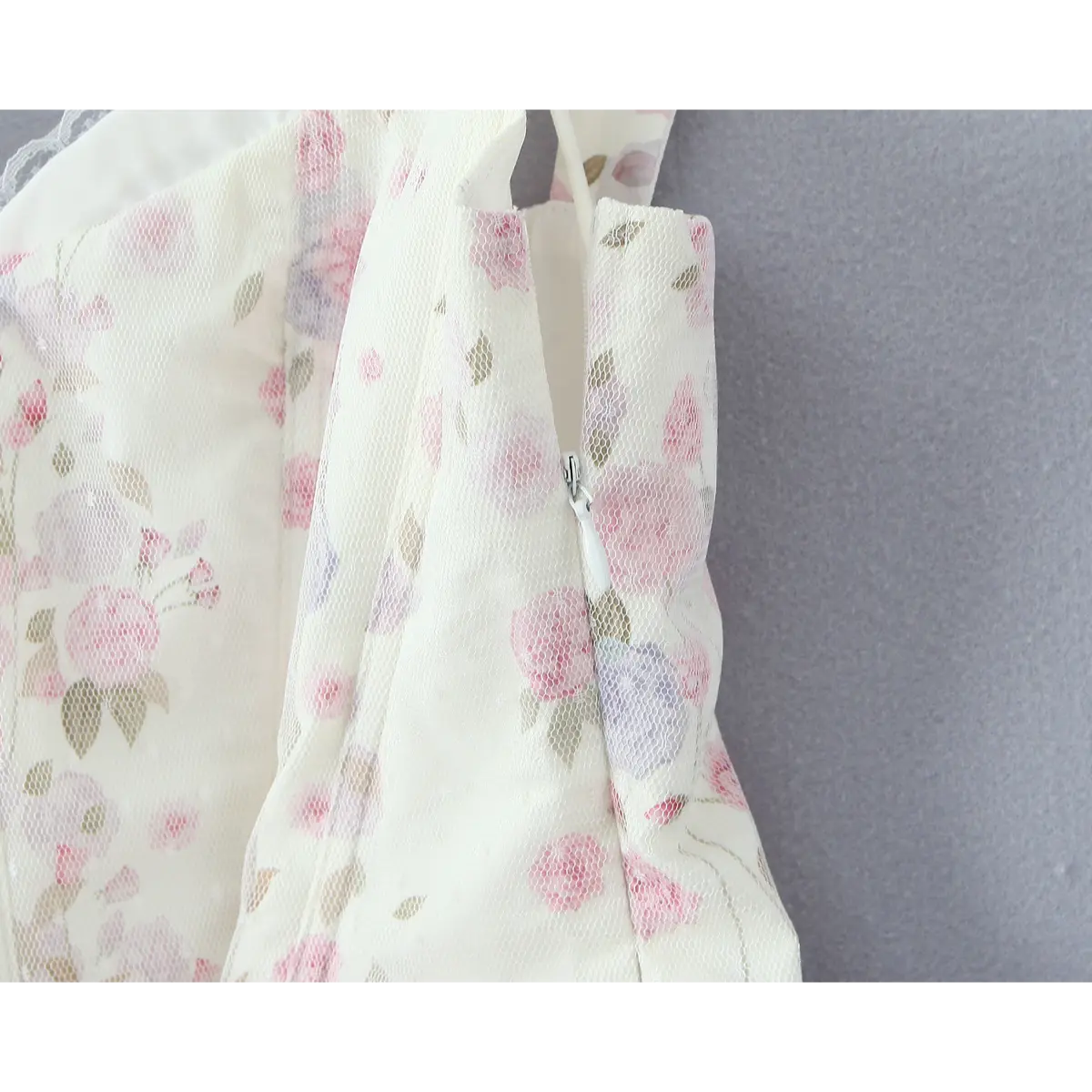Close-up of invisible side zipper, fully integrated into the floral mesh fabric.