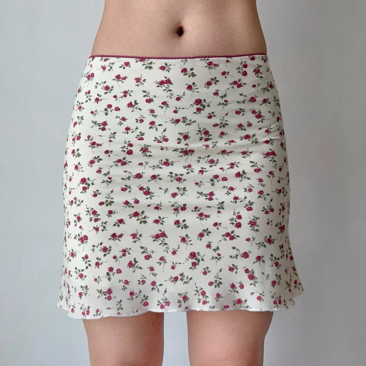 Close-up of the matching mini skirt, showing the rose print and ruffled hem.