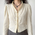 Model wearing cream ruffle stand‑collar cropped jacket, double button placket, pleated puff shoulders, torso front shot