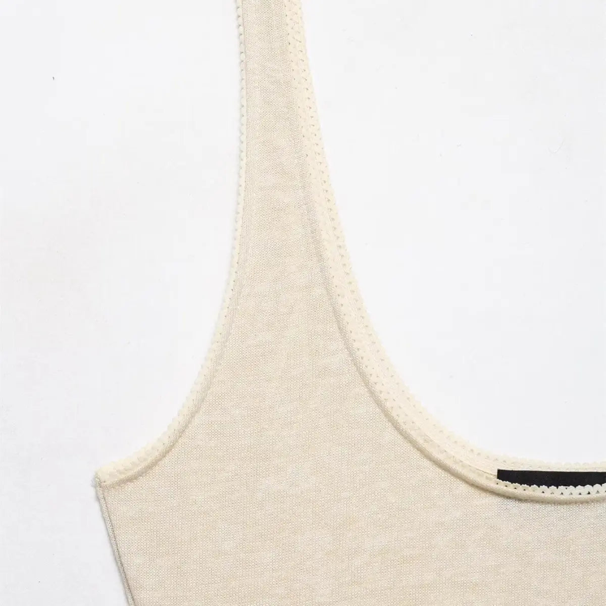 Close-up of the scalloped lace trim along the scoop neckline and armholes.