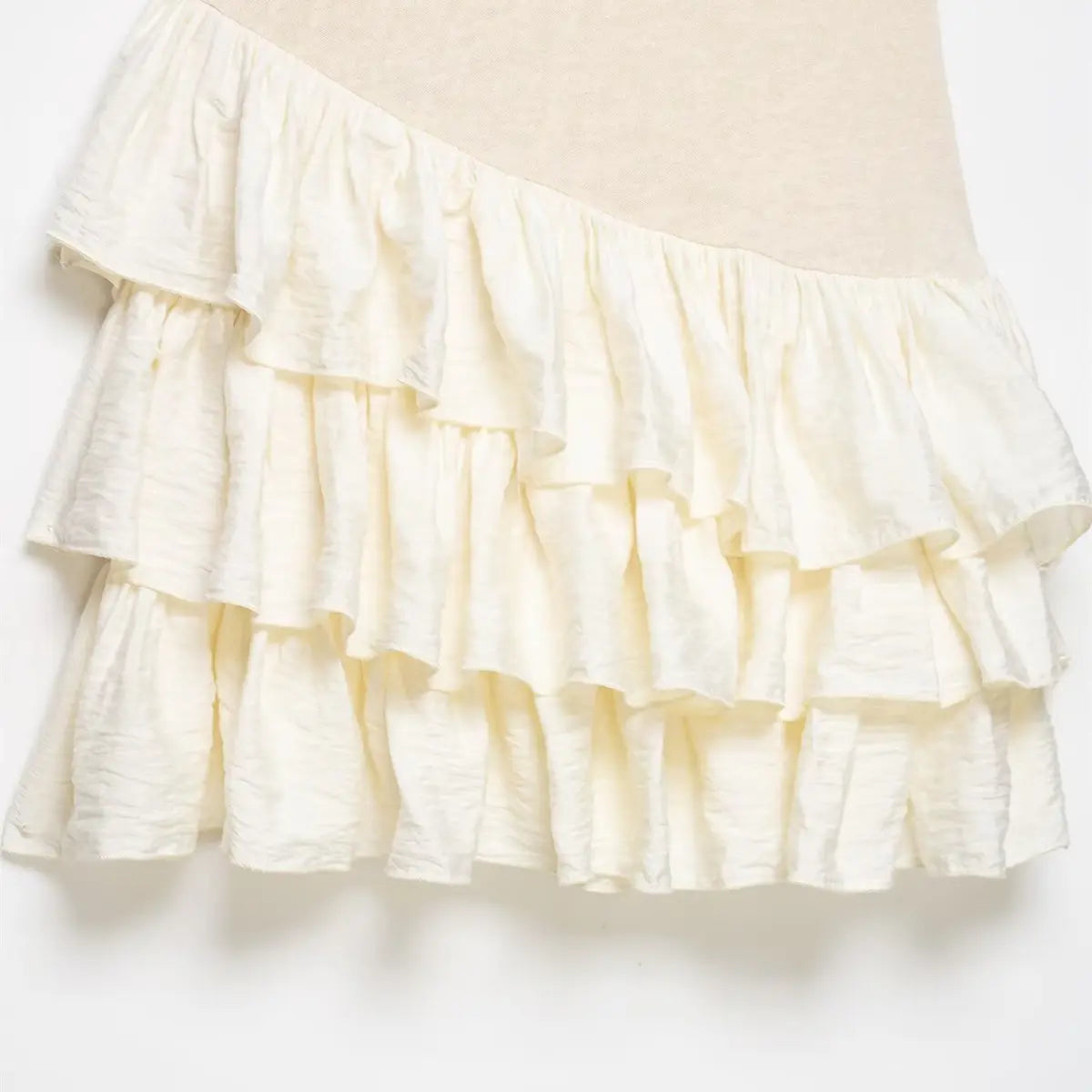Close-up of the tiered ruffle skirt, showing the contrast between the knit bodice and lightweight fabric layers.