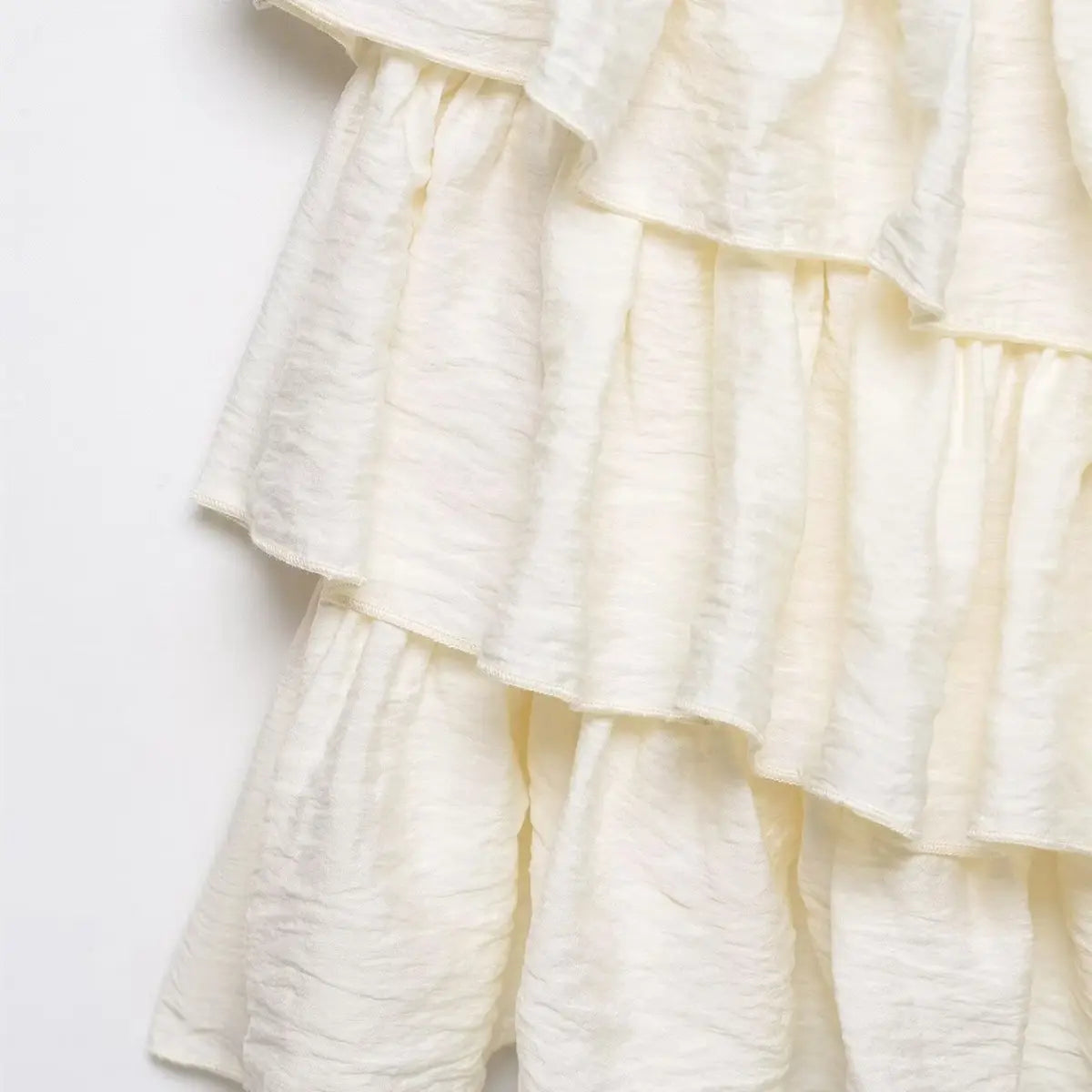 Close-up of the gathered ruffle layers, showing the texture and construction of the skirt hem.