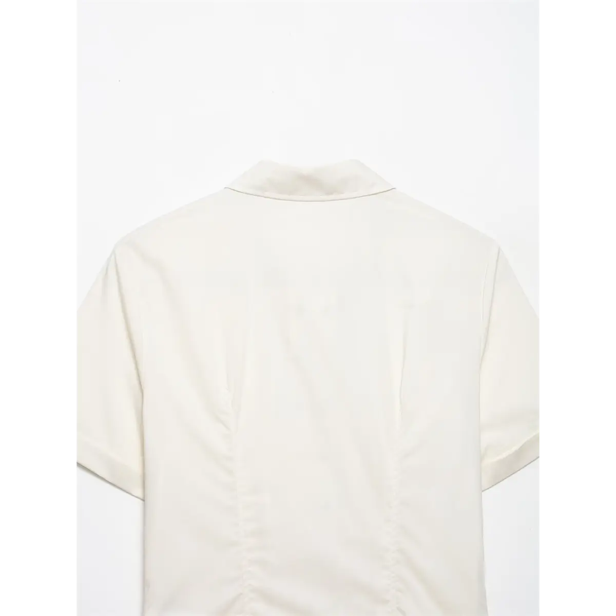Back view of cream ruffle front shirt, showing the structured collar and tailored seams